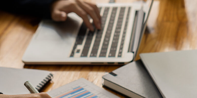 An accountant uses a calculator and computer while sticking to the concept of business accounting. Budget and Loan Hands of people making money and calculating expenses at the office vertical picture computer laptop